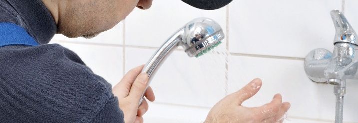 Handwerker testet Duschkopf